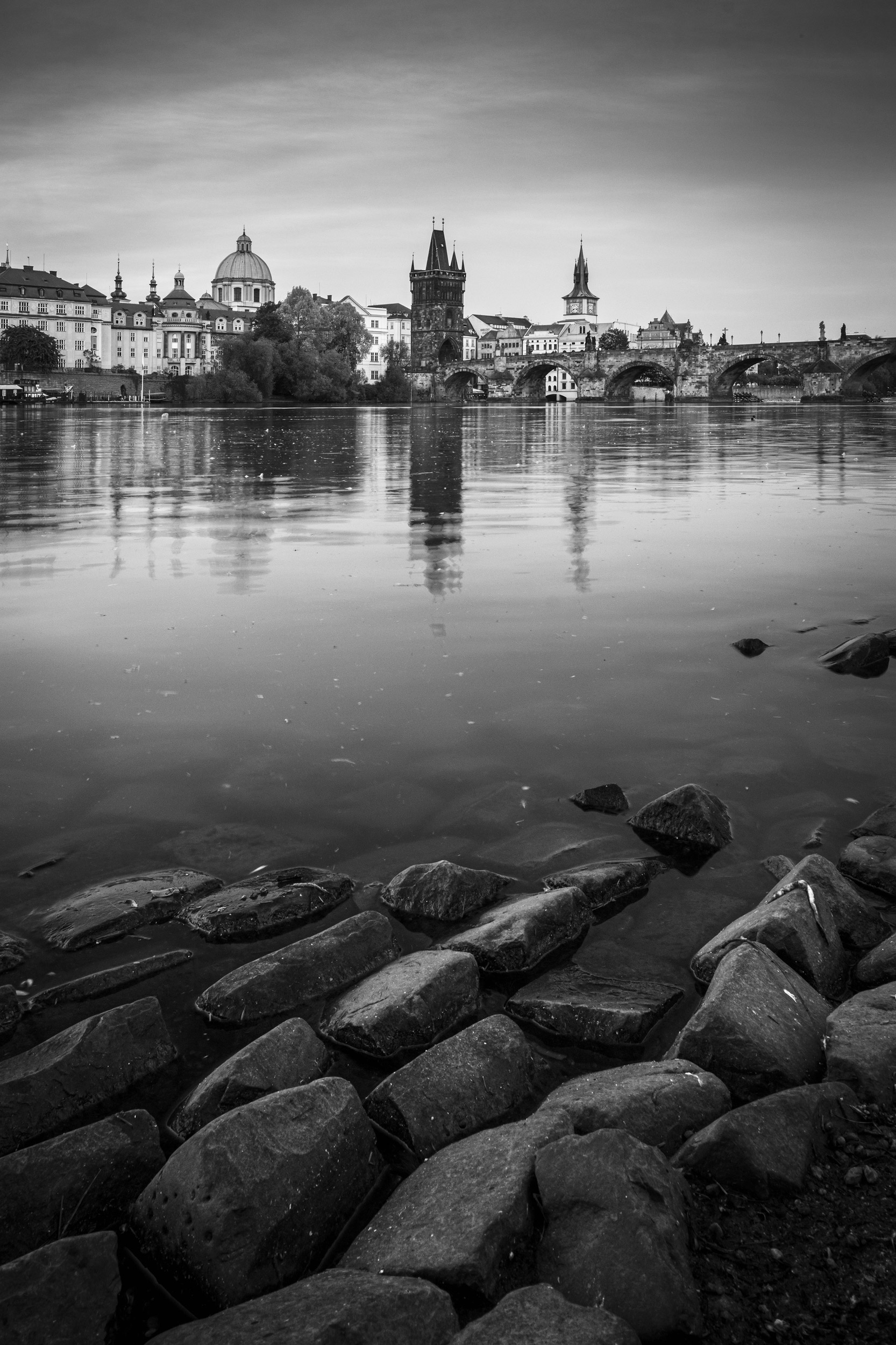 Prague skyline and bridge over river in black and white. Czech R