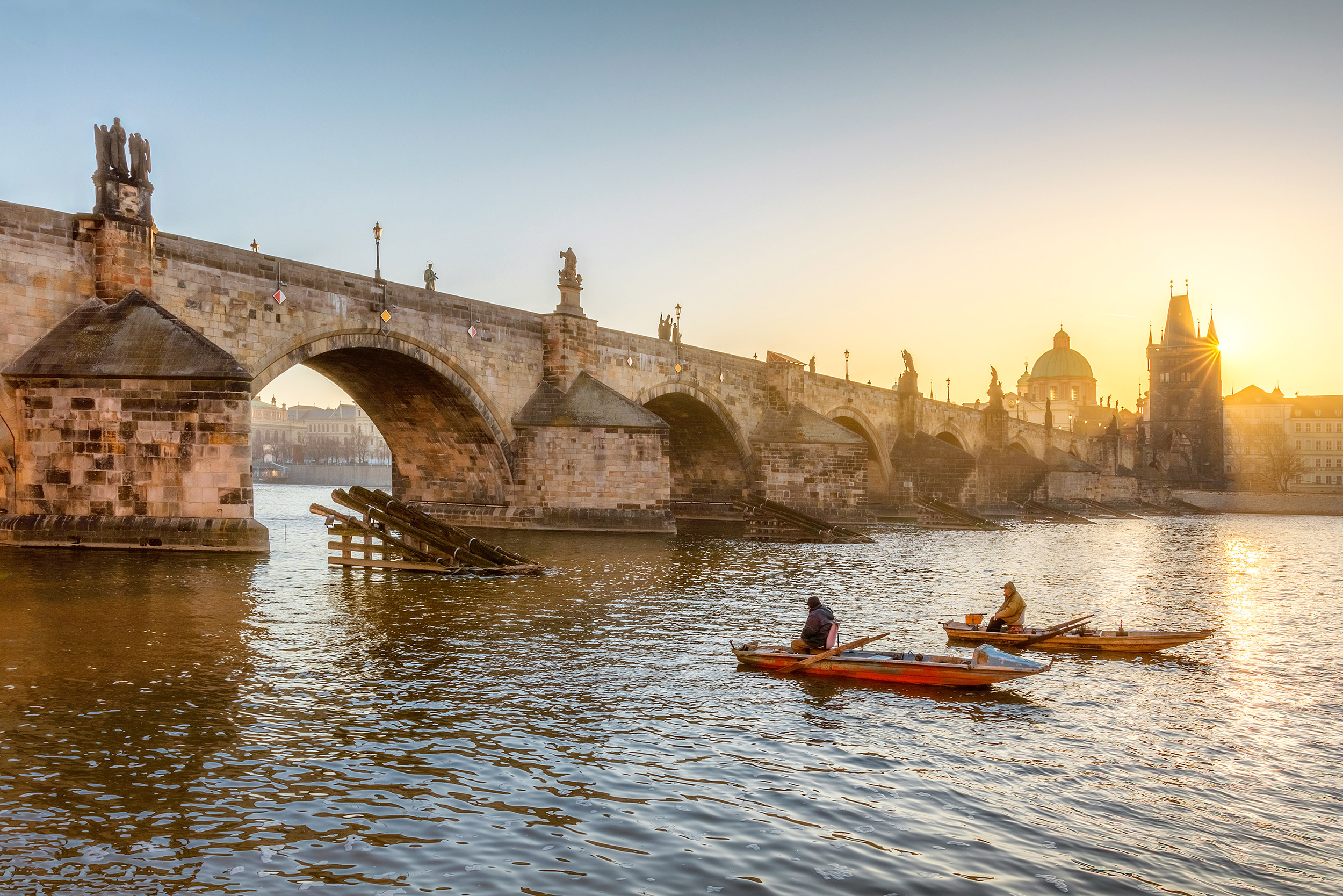 Two fishermen under the Charles bridge in Prague at the morning.