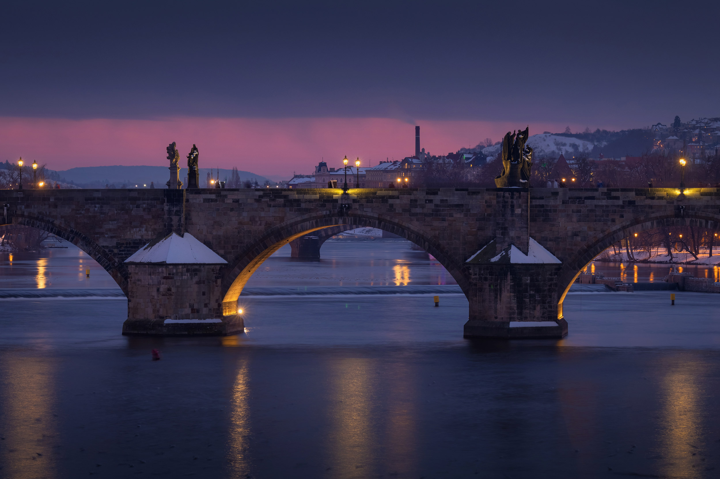 Detail view on illuminated Charles bridge at winter dusk, Prague