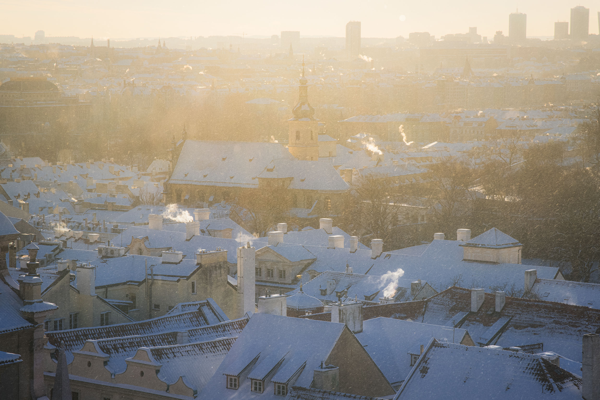 Winter morning light over snow-covered rooftops, Prague